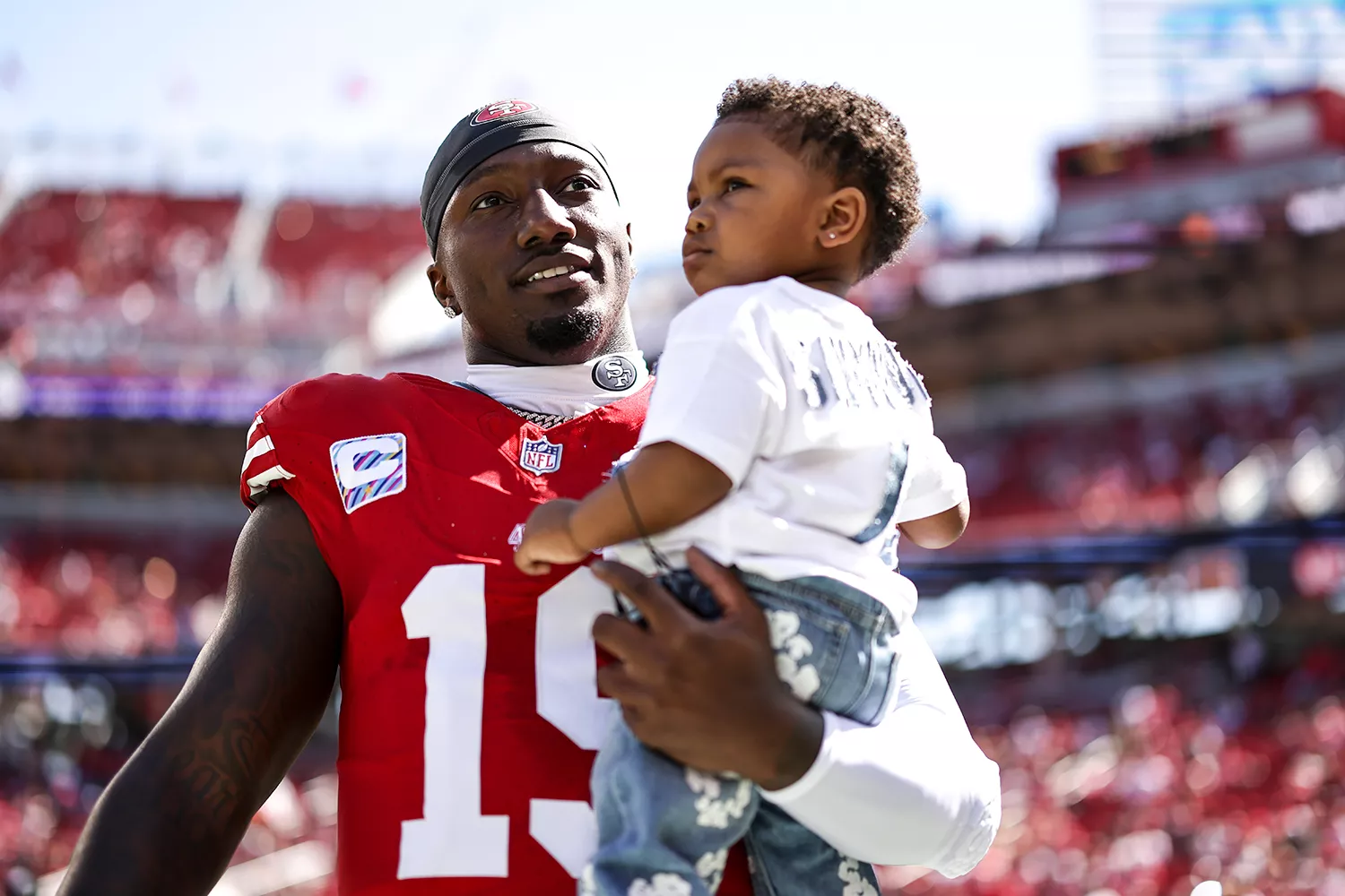 Deebo Samuel #19 of the San Francisco 49ers shares a moment with his son, Tyshun Raequan Samuel Jr., prior to an NFL football game between the San Francisco 49ers and the Arizona Cardinals at Levi's Stadium on October 01, 2023 in Santa Clara, California.